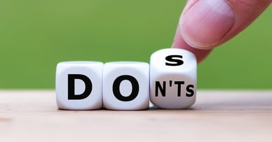 Three cubes that have letters on them, lined up to spell dos. 