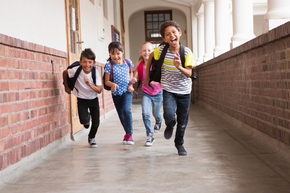 Children running down school hallway