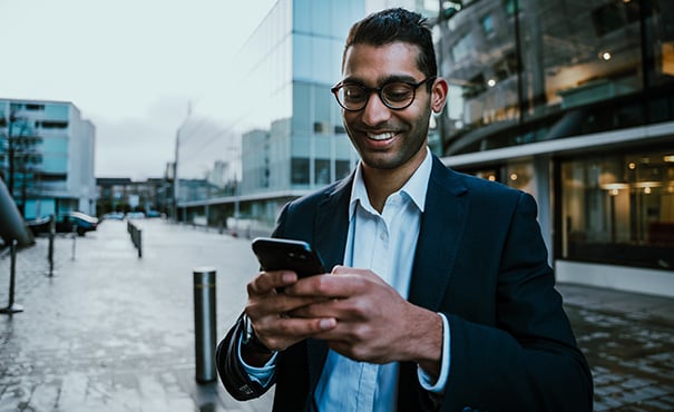 Business man smiling while texting